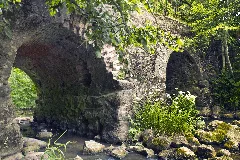 An Old Abandoned Stone Bridge Over Klūga River At Pumpuri